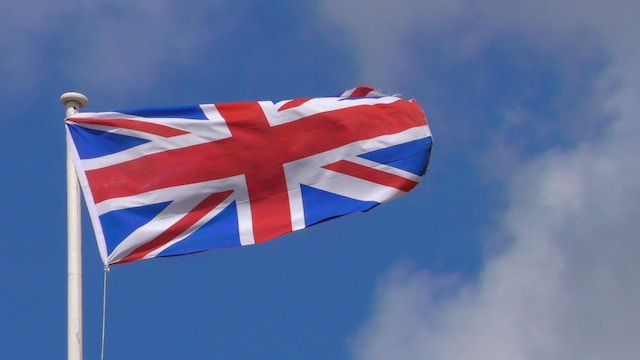 una bandiera inglese che sventola con un cielo azzurro sullo sfondo